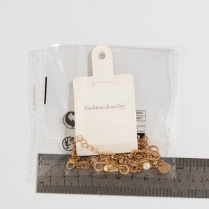 Top view of gold imitation pearl necklace size measurements on a metal ruler scale