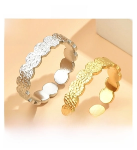 Detail of adjustable stainless steel flower rings with irregular embossed wave textures