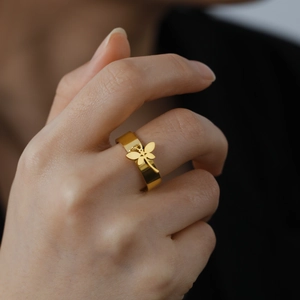 Polished gold stainless steel wide band ring featuring a delicate dragonfly charm pendant