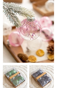 Close-up of decorative Christmas balls hanging on snow-covered pine branches