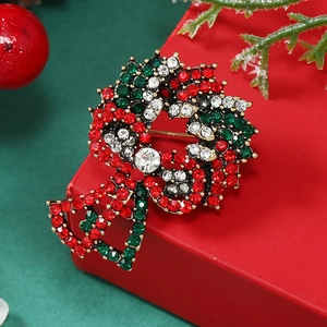 Macro shot of a Christmas wreath brooch with red and green crystals on a festive gift box