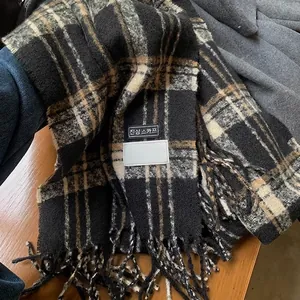 Macro detail of the thick checkered scarf with tassel fringe and Korean style woven labels