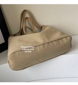 Detailed view of khaki canvas tote bag showing thick textured fabric and wide strap