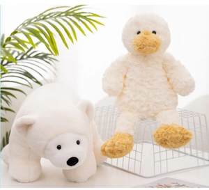 Close-up of soft plush polar bear and yellow duck toys in a cozy indoor setting