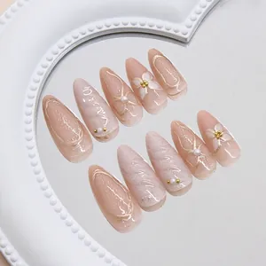 Cat eye pink press-on nails with 3D gold accents, hand-painted flowers, and pearls