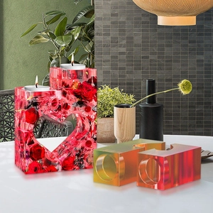 Dettaglio di un portacandele in resina a forma di cuore con rose rosse essiccate