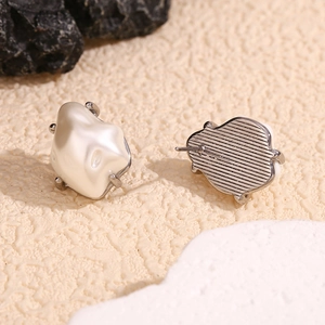 Macro shot of Baroque pearl stud earrings with silver-tone textured metal backing