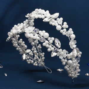 Detailed close-up of handmade white pearl and crystal flower headband for bridal hair styling