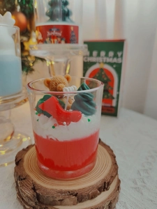 Detail of Christmas scented candle with 3D bear, tree and sock toppers in a glass cup
