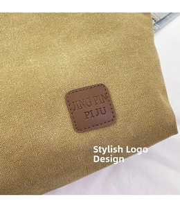 Close-up of yellow canvas tote bag featuring a square brown leather brand logo patch