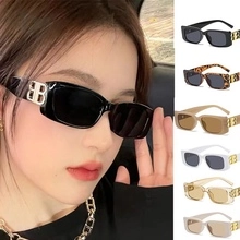 Detail view of double bridge rectangle sunglasses with metallic BB logo on the side temples