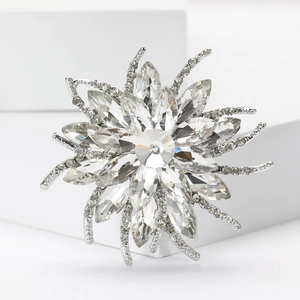 Macro detail of silver sunflower brooch with crystal rhinestones on geometric stone