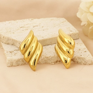 Detail of 18k gold plated earrings with spiral texture on natural stone pedestals