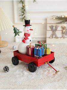 Detail view of a vintage red iron sleigh with a snowman and colorful gift boxes