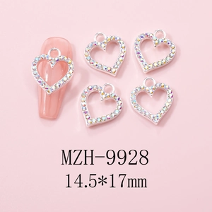 Close-up of heart hollow nail charms with AB rhinestones on a manicured nail and pink base