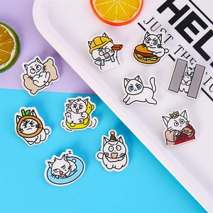 Set of cute acrylic cat brooches with various cartoon designs on a decorative tray