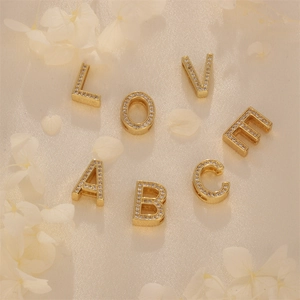 Gold-plated letter pendants with white zircon inlays for jewelry making on beige silk