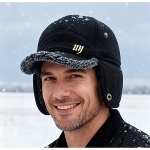 Detail of wool baseball cap with faux shearling ear flaps and gold NY logo in snow