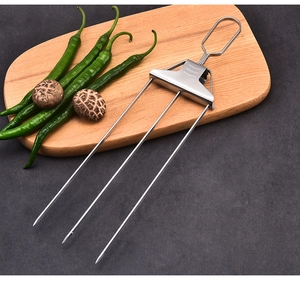 Close-up of a three-prong stainless steel BBQ fork with handle on dark background