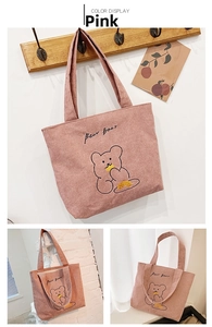 Detail of pink corduroy tote bag featuring a cute embroidered cartoon bear pattern