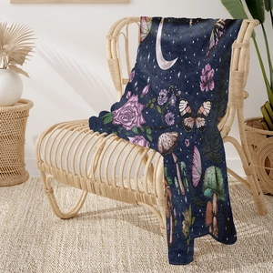 Detail of soft flannel blanket with celestial mushroom pattern on a rattan chair