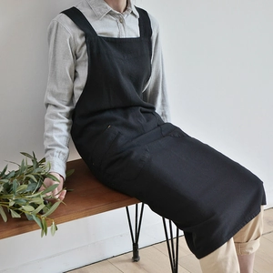 Detail of a minimalist black washed linen garden apron featuring a large front pocket