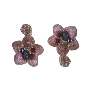 Orecchini asimmetrici a fiore rosa fatti a mano con ricami e perline su sfondo bianco