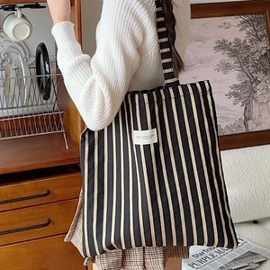Large striped canvas tote bag with black and yellow patterns for daily commuting use