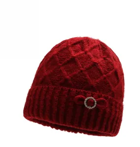 Detail of red knit hat with rhombus patterns and rhinestone bow for senior women