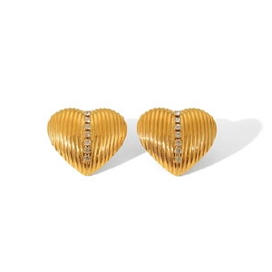 Detail of 18K gold heart earrings with sunburst texture and vertical white rhinestones
