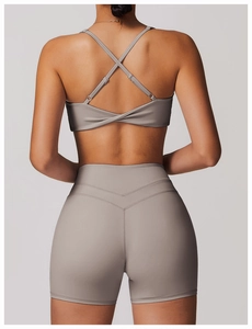 Détail des bretelles croisées et du tissu élastique de la brassière de sport grise