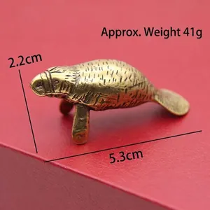 Close-up detail of vintage brass manatee figurine with antique texture and size markings