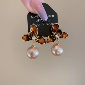 Detailed close-up of amber flower earrings with champagne pearls and 18K gold plating