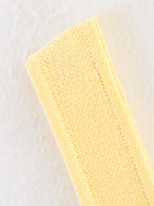 Gros plan détaillé sur la bretelle en maille côtelée jaune montrant le tissu