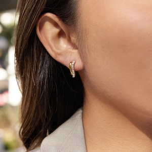 Gold twisted double-layer hoop earrings with rhinestones on a female model