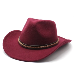 Detail of burgundy wool fedora hat featuring a brown braided band on a white background