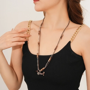 Double-layered necklace featuring brown dachshund puppy pendant on leather cord and bead chain
