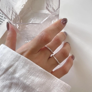 Close-up of elegant S925 sterling silver layered rings with sparkling zircon on a finger