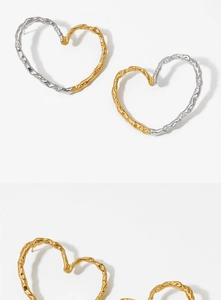 Detailed macro of heart earrings with hammered metal texture and gold silver finish