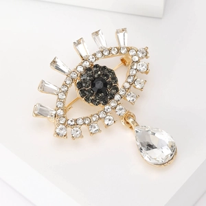 Detail of luxury Evil Eye brooch with blue crystals and sparkling teardrop pendant