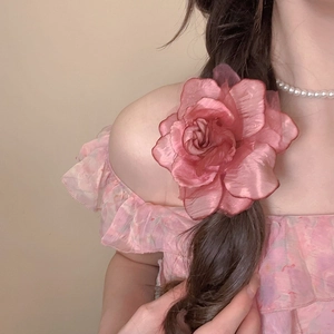 Detail of pink organza flower hair clip showing layered petals and delicate fabric texture