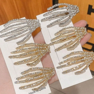 Détail de 6 barrettes mains de squelette en strass, finitions dorées et argentées