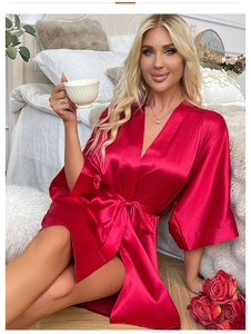 Detail of red satin robe with silky texture, v-neckline and elegant waist tie closure