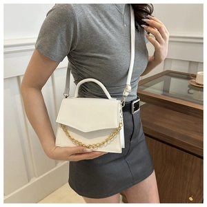 White mini square bag with gold chain detail worn by model for crossbody styling
