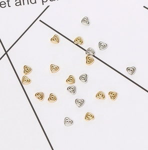 Macro shot of gold and silver hollow heart-shaped CCB beads for DIY jewelry making