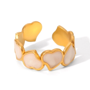 Close-up of golden heart-shaped rings with beige enamel inlay and adjustable band