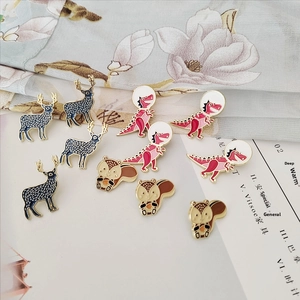 Collection of colorful enamel lapel pins featuring deer, astronaut dinosaur, and squirrel