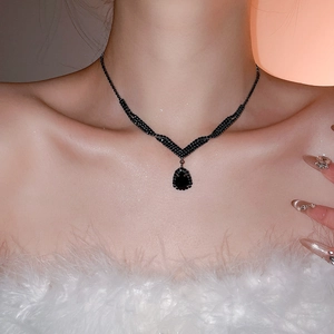 Close-up of a model wearing a luxurious black teardrop diamond pendant necklace