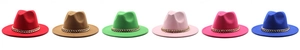 Flat lay of jazz fedora hats in six vibrant colors featuring bold gold chain accessories