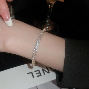 Close-up of a luxurious gold tennis bracelet with shimmering white cubic zirconia stones